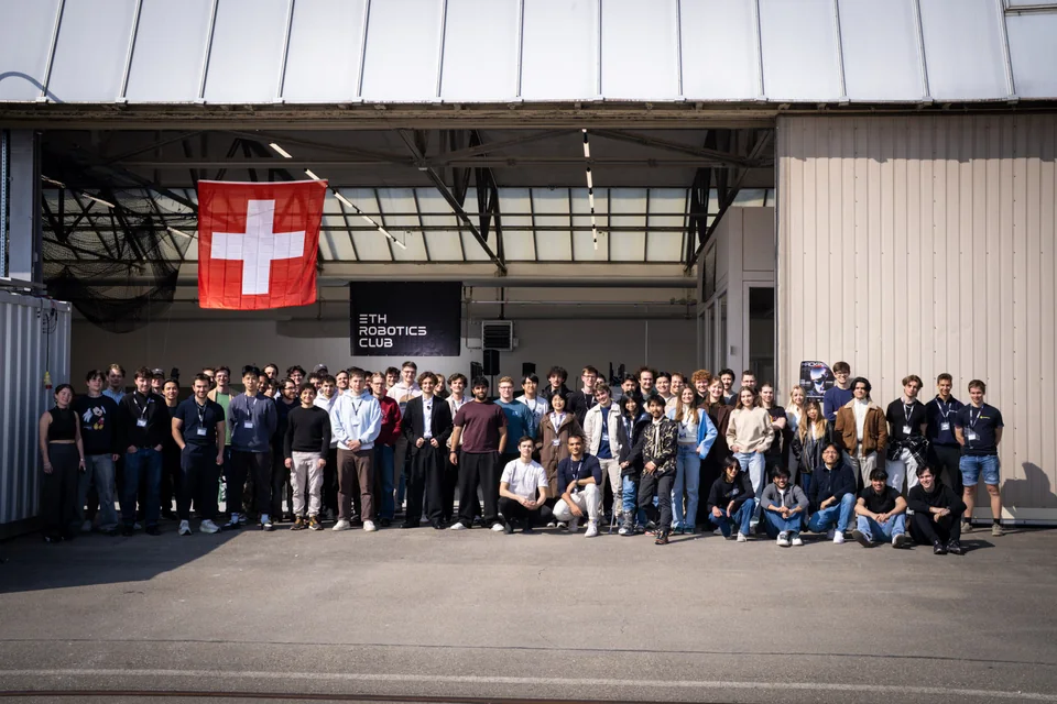 The ETH Robotics Club community gathered outside the Hangar beneath a Swiss flag